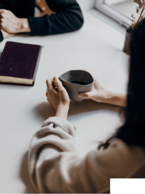 Women Holding Cup of Coffee on White Table