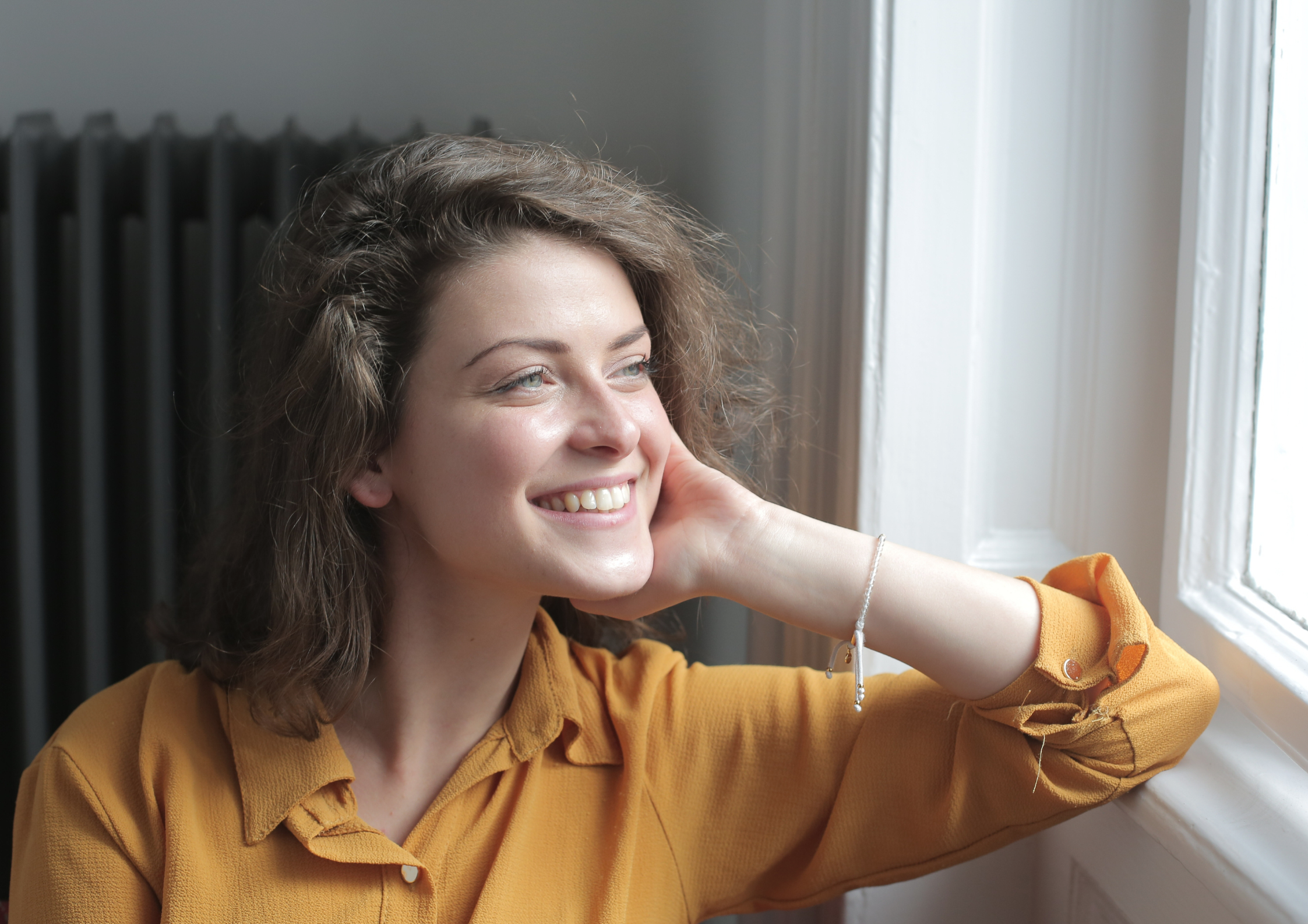 Happy woman looking out the window with ADHD support in Guildford