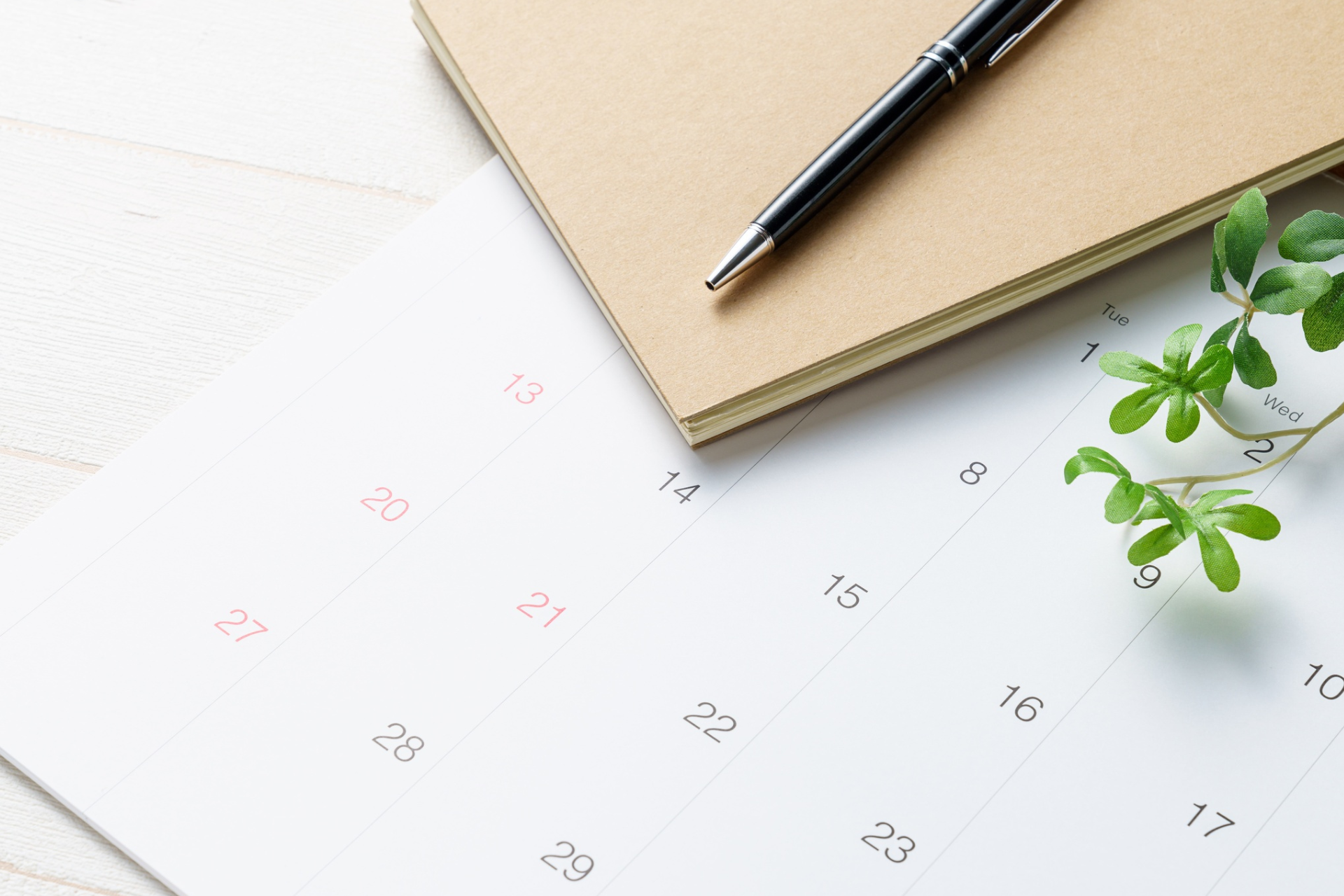 Calendar, notepad, and plant on desk representing therapist private practice planning and growth