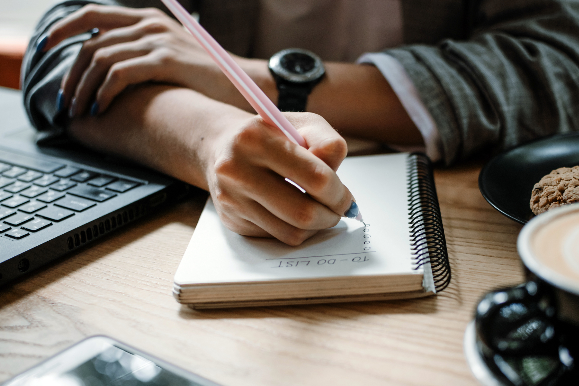 Man at desk writing a to-do list to manage tasks and improve focus, illustrating ADHD support strategies.