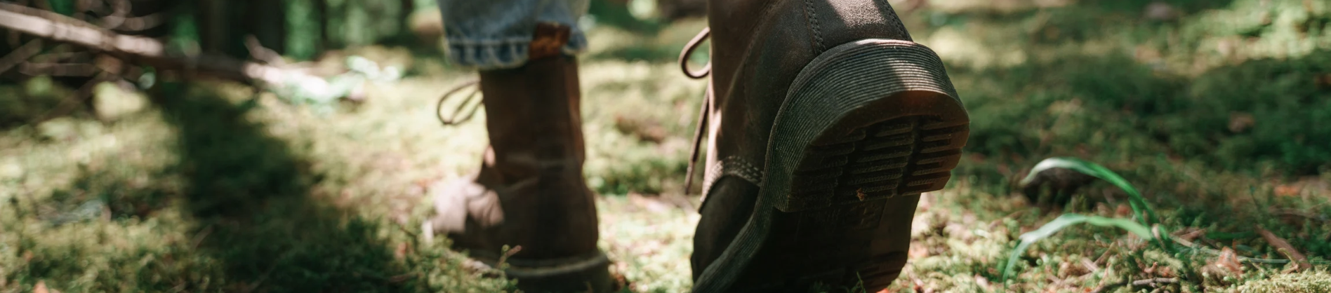 Wide banner showing a walking boot in the forest with leaves on the sole, symbolising the journey of emotional resilience and therapy for sensitivity