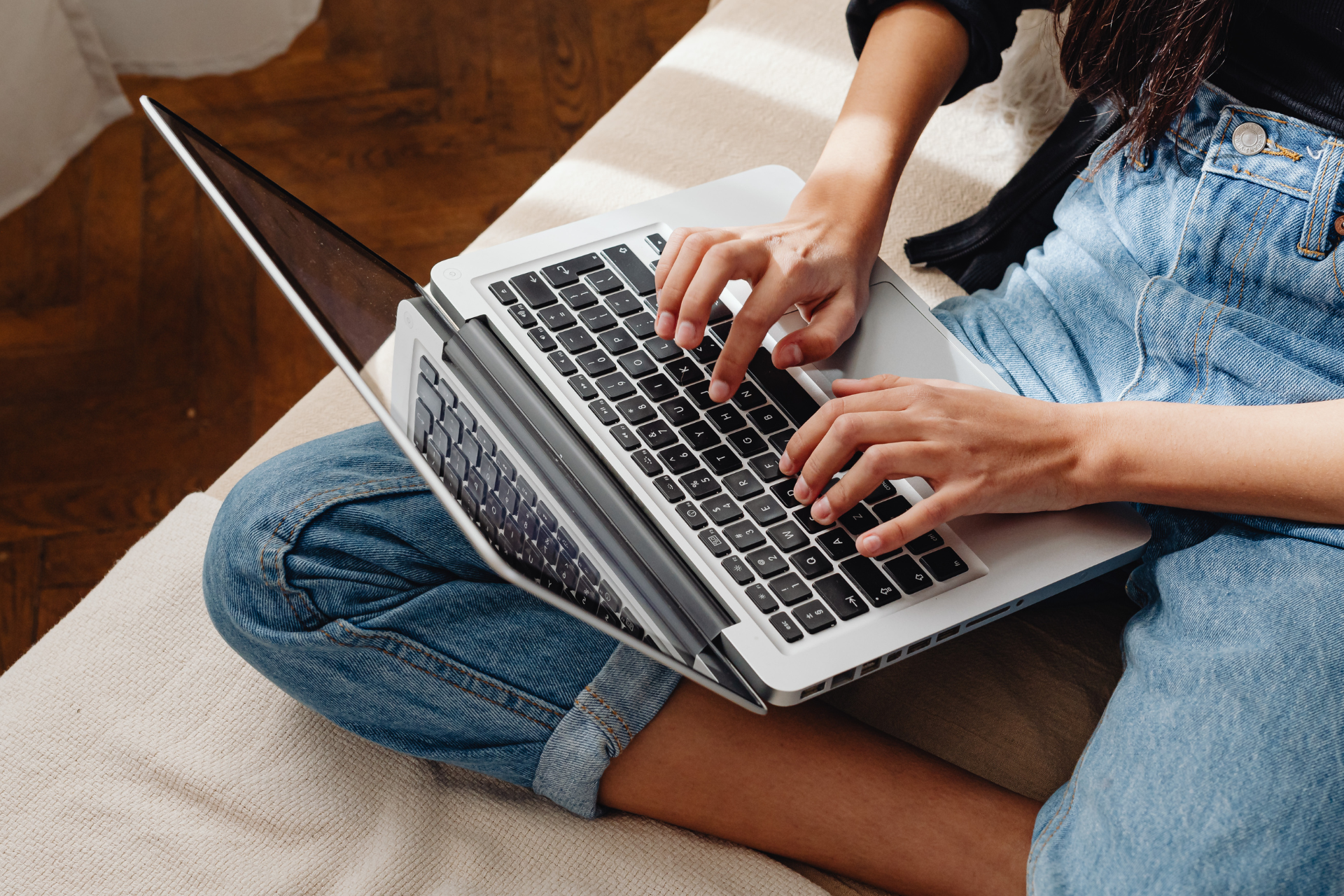 Woman sitting on a sofa using a laptop to search for low-cost therapy options from home